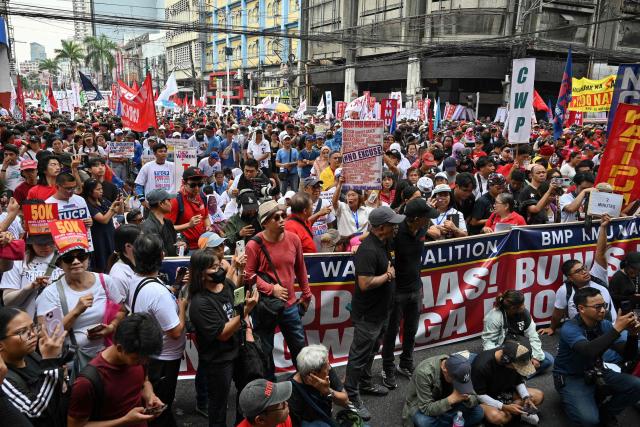 Workers gather along a street during a May Day rally near Malacanang Palace in Manila on May 1, 2026. (Photo by Ted ALJIBE / AFP)