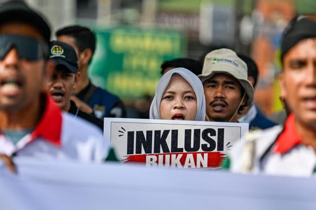 Workers participate in a rally to mark International Labour Day in Banda Aceh on May 1, 2026. (Photo by CHAIDEER MAHYUDDIN / AFP)