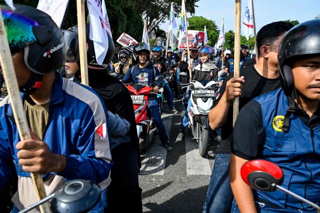 Workers on motorbikes participate in a rally to mark International Labour Day in Banda Aceh on May 1, 2026. (Photo by CHAIDEER MAHYUDDIN / AFP)