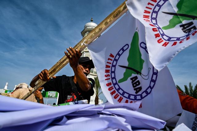 A worker prepares before a rally to mark International Labour Day in Banda Aceh on May 1, 2026. (Photo by CHAIDEER MAHYUDDIN / AFP)