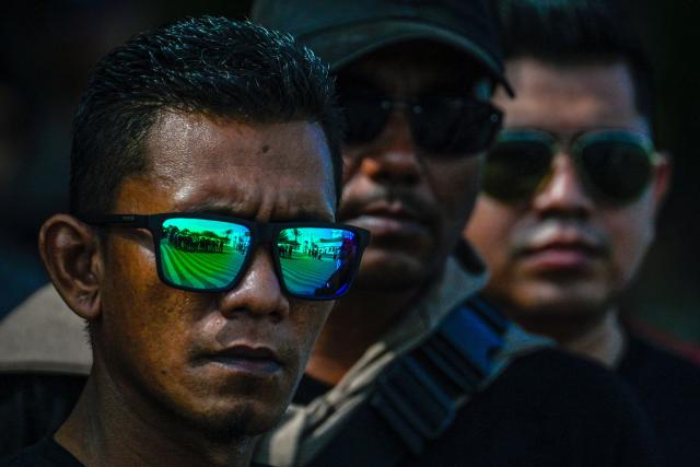 A man wearing sunglasses looks on as he takes part in a rally to mark International Labour Day in Banda Aceh on May 1, 2026. (Photo by CHAIDEER MAHYUDDIN / AFP)