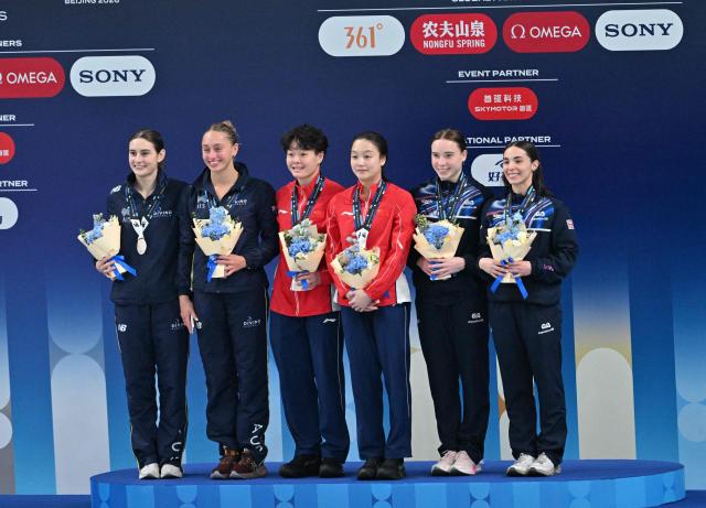 Gold medallists Chen Jia and Chen Yiwen of China (C), silver medallists Maddison Keeney and Alysha Koloi of Australia (L) and bronze medallists Yasmin Harper and Scarlett Mew Jensen of Britain (R) pose during the medal ceremony for the women's 3m synchronised diving at the World Aquatics Diving World Cup 2026 super finals in Beijing on May 1, 2026. (Photo by ADEK BERRY / AFP)