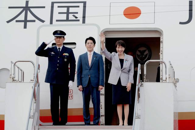 Japan's Prime Minister Sanae Takaichi (R) waves as she departs on an official trip to Vietnam and Australia at Haneda Airport in Tokyo on May 1, 2026. (Photo by Kazuhiro NOGI / AFP)