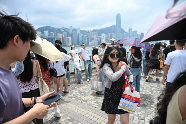 Tourists visit Victoria Harbour during China's Labour Day golden week holiday in Hong Kong on May 1, 2026. (Photo by Peter PARKS / AFP)