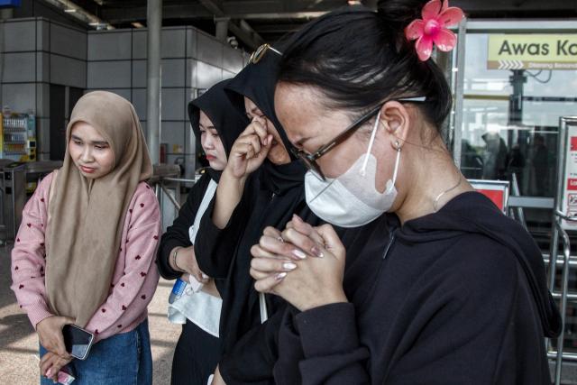 People offer flowers and pray for the victims of a train collision that killed 16 people at Bekasi Timur Station in Bekasi, West Java, on May 1, 2026. A long-distance train slammed into the last, women-only carriage of a stationary commuter train near the Bekasi Timur station late on April 27, prompting a nearly 12-hour rescue effort with crews prying open mangled carriages. (Photo by Aditya Irawan / AFP)