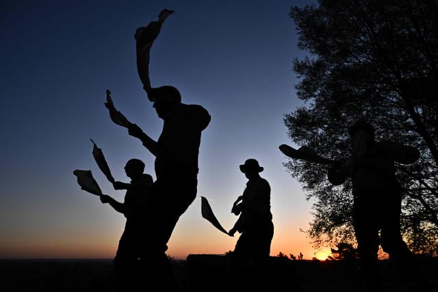 The Ashdown Forest Morris Men sing in May Day as they perform at sunrise in the Ashdown Forest, south of London on May 1, 2026. Historically, in rural Britain, May Day celebrations were associated with the fertility of spring and the start of summer. (Photo by Ben STANSALL / AFP)