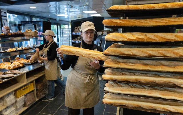 An employee works in a bakery in Quimper, western France, on May 1, 2026. The debate over whether independent bakers, florists and other small traders should be allowed to employ staff on May 1 has taken on a national dimension in recent weeks, with the government indicating that bakers and florists may open with their staff as of this year, before a bill formalises the arrangement from next year. (Photo by Fred TANNEAU / AFP)
