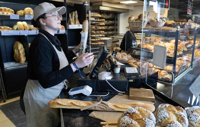 An employee serves a client in a bakery in Quimper, western France, on May 1, 2026. The debate over whether independent bakers, florists and other small traders should be allowed to employ staff on May 1 has taken on a national dimension in recent weeks, with the government indicating that bakers and florists may open with their staff as of this year, before a bill formalises the arrangement from next year. (Photo by Fred TANNEAU / AFP)