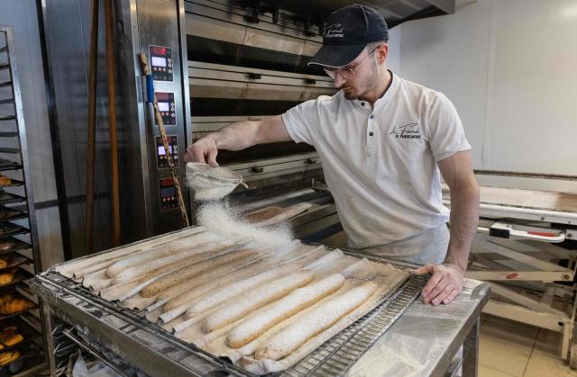 An employee works in a bakery in Quimper, western France, on May 1, 2026. The debate over whether independent bakers, florists and other small traders should be allowed to employ staff on May 1 has taken on a national dimension in recent weeks, with the government indicating that bakers and florists may open with their staff as of this year, before a bill formalises the arrangement from next year. (Photo by Fred TANNEAU / AFP)