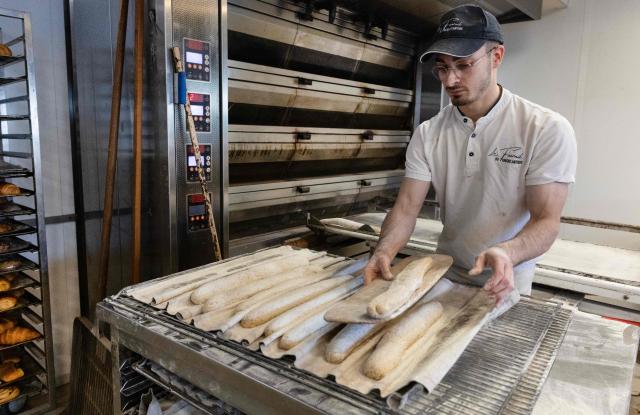 An employee works in a bakery in Quimper, western France, on May 1, 2026. The debate over whether independent bakers, florists and other small traders should be allowed to employ staff on May 1 has taken on a national dimension in recent weeks, with the government indicating that bakers and florists may open with their staff as of this year, before a bill formalises the arrangement from next year. (Photo by Fred TANNEAU / AFP)
