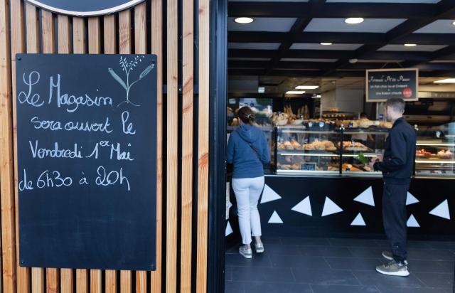 Clients wait in line in a bakery in Quimper, western France, on May 1, 2026. The debate over whether independent bakers, florists and other small traders should be allowed to employ staff on May 1 has taken on a national dimension in recent weeks, with the government indicating that bakers and florists may open with their staff as of this year, before a bill formalises the arrangement from next year. (Photo by Fred TANNEAU / AFP)