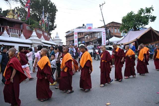 Novice Buddhist monks arrive to offer prayers at the Swayambhunath Stupa during Buddha Purnima commemorating Buddha's birthday, in Kathmandu on May 1, 2026. (Photo by PRAKASH MATHEMA / AFP)