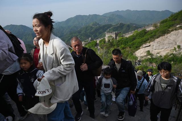 People climb the Great Wall of China at Badaling, north of Beijing, on May 1, 2026, on the first day of a five-day national May Day holiday. (Photo by GREG BAKER / AFP)