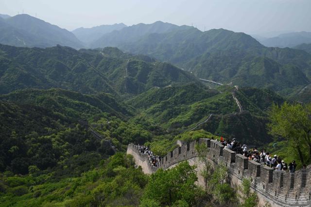 People walk along the Great Wall of China at Badaling, north of Beijing, on May 1, 2026, on the first day of a five-day national May Day holiday. (Photo by GREG BAKER / AFP)