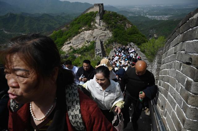 People climb the Great Wall of China at Badaling, north of Beijing, on May 1, 2026, on the first day of a five-day national May Day holiday. (Photo by GREG BAKER / AFP)