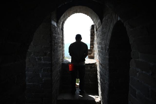 A man stands in a watch tower on the Great Wall of China at Badaling, north of Beijing, on May 1, 2026, on the first day of a five-day national May Day holiday. (Photo by GREG BAKER / AFP)