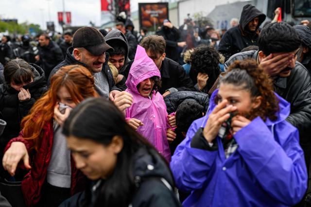 Protestors react as Turkish police use pepper spray to disperse demonstrators during a May Day (Labour Day) rally, marking international Workers' Day, in Besiktas, a district of Istanbul, on May 1, 2026. Turkish police fired tear gas and arrested dozens of people holding May Day demonstrations in Istanbul, AFP journalists said. Two groups were specially singled out in the city's European side after signalling their intention to march to Taksim square -- the scene of several anti-government protests in the past -- which was sealed off overnight by police. (Photo by Yasin AKGUL / AFP)