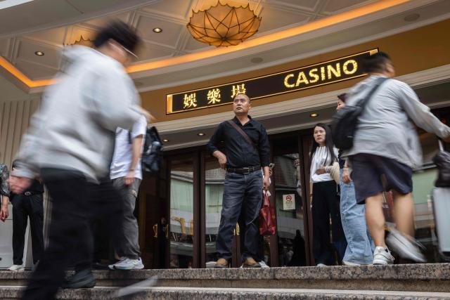 A visitor stands outside the door of the casino at the Wynn hotel resort during the Labour Day holiday in Macau on May 1, 2026. (Photo by Eduardo Leal / AFP)