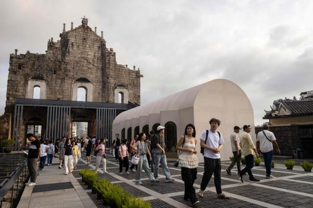 Visitors walk around the Ruins of Saint Paul's during the Labour Day holiday in Macau on May 1, 2026. (Photo by Eduardo Leal / AFP)