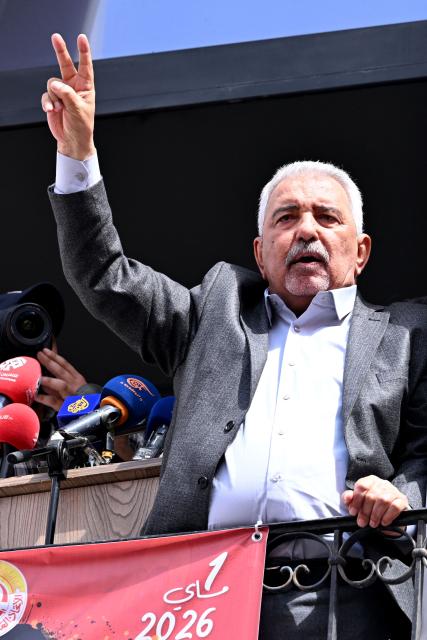 Slaheddine Selmi, the newly elected Secretary General of the Tunisian General Labour Union (UGTT), flashes the V-sign for victory from the balcony of the headquarters during the workers' rally marking May Day, the International Workers' Day, in Tunis on May 1, 2026. (Photo by FETHI BELAID / AFP)