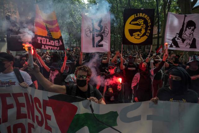 Members of an anti-fascist group hold flares and placards as they take part in a May Day (Labour Day) rally, marking International Workers' Day, in Toulouse on May 1, 2026. (Photo by Ed JONES / AFP)