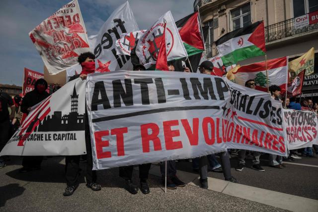 Demonstrators hold a banner reading "Anti-imperialist and revolutionary" as they take part in a May Day (Labour Day) rally, marking International Workers' Day, in Toulouse on May 1, 2026. (Photo by Ed JONES / AFP)
