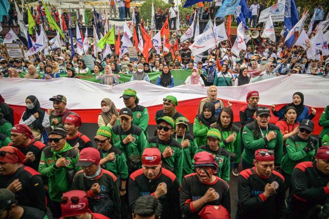 Indonesian workers unfurl the Indonesian flag during a May Day rally marking International Workers' Day in front of the East Java Governor’s Office in Surabaya on May 1, 2026. (Photo by JUNI KRISWANTO / AFP)
