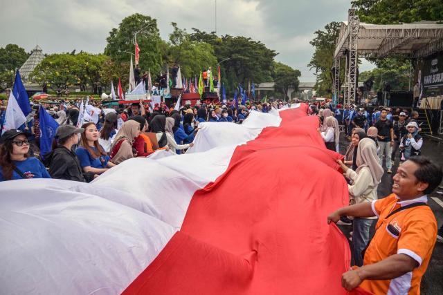 Indonesian workers unfurl the Indonesian flag during a May Day rally marking International Workers' Day in front of the East Java Governor’s Office in Surabaya on May 1, 2026. (Photo by JUNI KRISWANTO / AFP)