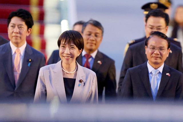 Japan's Prime Minister Sanae Takaichi (C) is seen upon arrival at Noi Bai International Airport in Hanoi on May 1, 2026. (Photo by Hoang Long / AFP)