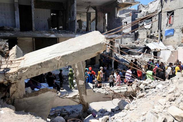 Displaced Palestinians wait amid the rubble of buildings destroyed by the Israeli military to collect food from a charity kitchen in the Bureij refugee camp in the central Gaza Strip on May 1, 2026. The war on the Gaza Strip was sparked following the militant Palestinian group Hamas's October 7, 2023 attack on Israel, which resulted in the deaths of 1,221 people. Israel's retaliatory assault on Gaza has killed at least 72,600 people, according to figures from the health ministry that the UN considers reliable. with th  majority of Gaza's 2.4 million people being displaced. (Photo by Eyad Baba / AFP)