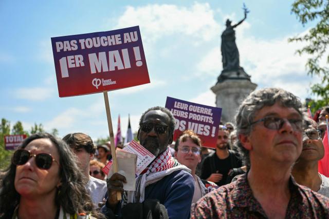 A man holds a placard reading "Hands off May 1" during a May Day rally marking International Workers' Day in Paris, on May 1, 2026. (Photo by Julie SEBADELHA / AFP)