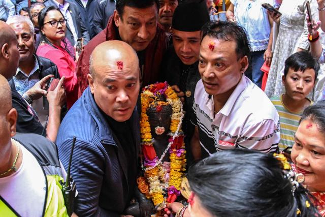 Devotees carry a sculpture of the Buddha to be reinstalled at a temple in Kathmandu on May 1, 2026. A centuries-old sculpture of lord Buddha was re-installed at its rightful home in the Nepali capital Kathmandu on May 1, decades after it was stolen and later emerged in the United States. (Photo by Prakash MATHEMA / AFP)
