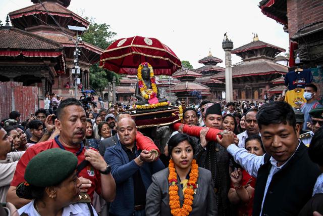 Devotees carry a sculpture of the lord Buddha to be reinstalled at a temple in Kathmandu on May 1, 2026. A centuries-old sculpture of lord Buddha was re-installed at its rightful home in the Nepali capital Kathmandu on May 1, decades after it was stolen and later emerged in the United States. (Photo by Prakash MATHEMA / AFP)