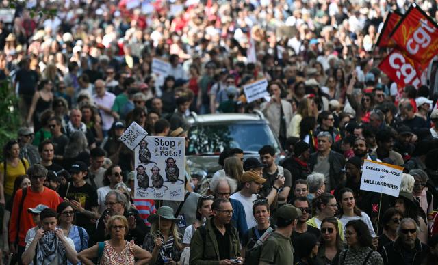 People take part in a May Day rally marking International Workers' Day in Paris, on May 1, 2026. (Photo by Julie SEBADELHA / AFP)