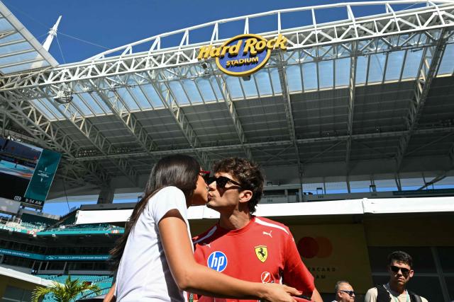 Ferrari's Monegasque driver Charles Leclerc kisses his wife Alexandra Saint Mleux Leclerc as they arrive for a practice session for the 2026 Miami Formula One Grand Prix at Miami International Autodrome in Miami Gardens, Florida, on May 1, 2026. (Photo by CHANDAN KHANNA / AFP)