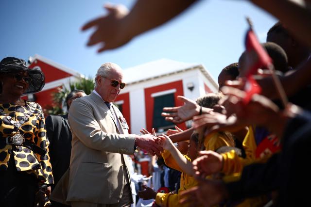 Britain's King Charles III greets a group of children during a ceremonial welcome at King's Square in St. George's, Bermuda, on May 1, 2026. King Charles III is in Bermuda for his first visit to a British Overseas Territory as Sovereign. (Photo by HENRY NICHOLLS / POOL / AFP)