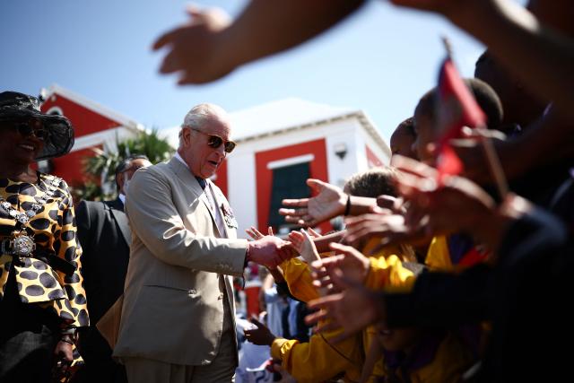 Britain's King Charles III greets a group of children during a ceremonial welcome at King's Square in St. George's, Bermuda, on May 1, 2026. King Charles III is in Bermuda for his first visit to a British Overseas Territory as Sovereign. (Photo by HENRY NICHOLLS / POOL / AFP)