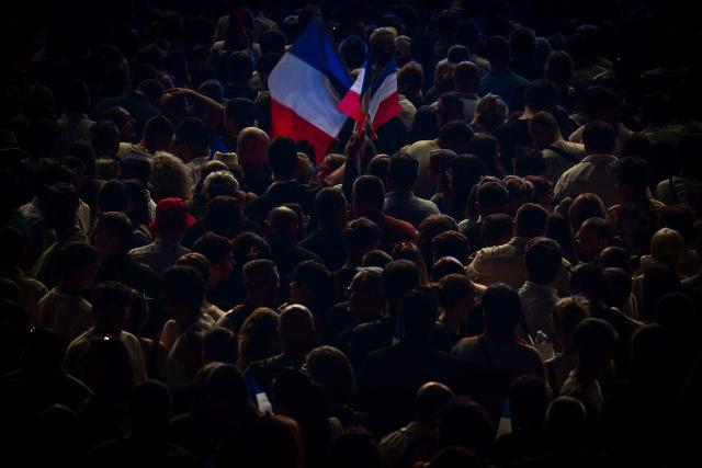 French far-right party Rassemblement National (RN) supporters waves France's national flag during the "Fete de la Nation" meeting in Macon on May 1, 2026. (Photo by OLIVIER CHASSIGNOLE / AFP)