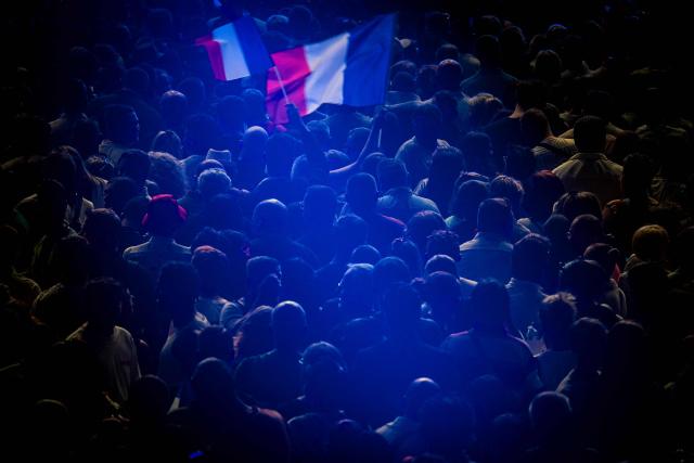 French far-right party Rassemblement National (RN) supporters waves France's national flag during the "Fete de la Nation" meeting in Macon on May 1, 2026. (Photo by OLIVIER CHASSIGNOLE / AFP)