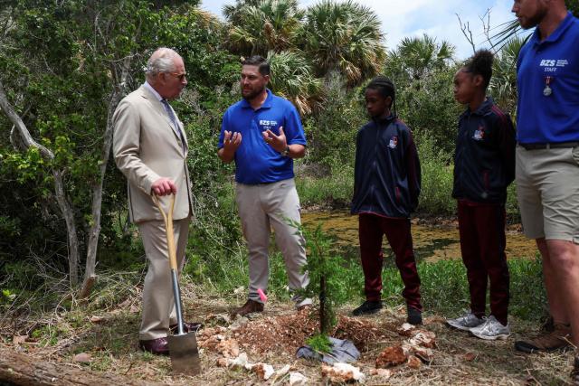 Britain's King Charles plants a tree during a visit to a ‘Living Classroom’ on Trunk Island on May 1, 2026 in Hamilton, Bermuda. King Charles III is in Bermuda for his first visit to a British Overseas Territory as Sovereign. (Photo by Suzanne Plunkett / POOL / AFP)