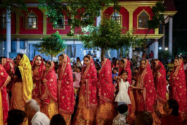 Brides arrive to get married during a mass wedding ceremony in Varanasi on May 1, 2026. (Photo by Niharika KULKARNI / AFP)