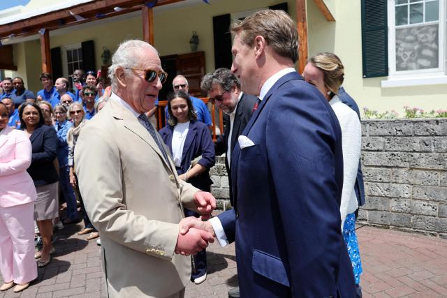 Britain's King Charles III speaks with Claire Larner (C) and Former assistant equerry James Larner during a visit to the Bermuda Aquarium Museum on May 01, 2026 in Hamilton, Bermuda. King Charles III is in Bermuda for his first visit to a British Overseas Territory as Sovereign. (Photo by Chris Jackson / POOL / AFP)