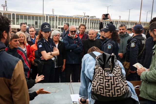 Police officers watch members of the Global Sumud Flotilla vessels, intercepted by the Israeli Navy in international waters, demonstrating in the town of Ierapetra in the island of Crete, Greece, on May 1, 2026. (Photo by Costas METAXAKIS / AFP)