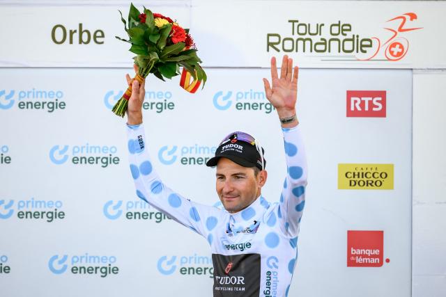 Tudor Pro Cycling Team’s Swiss rider Roland Thalmann wearing the climber's blue dot jersey celebrates during the podium ceremony of the third stage of the Tour of Romandie UCI cycling World tour, a 176.6 km loop departing and arriving in Orbe, Switzerland, on May, 1, 2026. (Photo by Fabrice COFFRINI / AFP)
