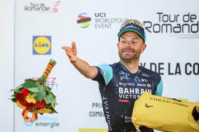 Bahrain Victorious’ Italian rider Damiano Caruso awarded as best fighter throws flowers during the podium ceremony of the third stage of the Tour of Romandie UCI cycling World tour, a 176.6 km loop departing and arriving in Orbe, Switzerland, on May, 1, 2026. (Photo by Fabrice COFFRINI / AFP)