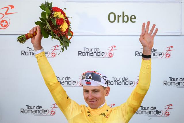 UAE Team Emirates-XRG's Slovenian rider Tadej Pogacar wearing the overall leader's yellow jersey raises his arms during the podium ceremony of the third stage of the Tour of Romandie UCI cycling World tour, a 176.6 km loop departing and arriving in Orbe, Switzerland, on May, 1, 2026. (Photo by Fabrice COFFRINI / AFP)