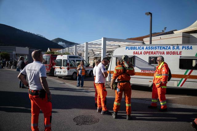 Volunteers, emergency and civil personnel stand at the Civil Protection Headquarters as they respond to a wildfire, in Asciano on May 1, 2026. Italian authorities evacuated some 3,500 people in its famed Tuscany region on May 1, 2026 as they try to tame a wildfire that has been raging for more than 24 hours. Over 800 hectares (nearly 2,000 acres) have been ravaged by the fire in the mountains between the historic cities of Lucca and Pisa. (Photo by Federico SCOPPA / AFP)