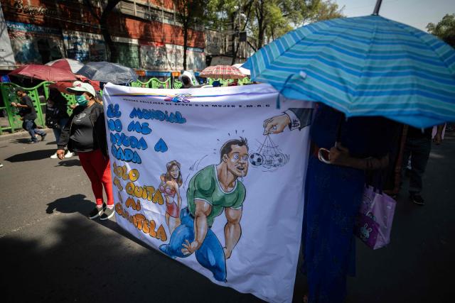 Sex workers hold a banner reading "The World Cup does not help me at all, it only takes away my clientele" as they protest for better working conditions amid restrictions linked to the upcoming FIFA 2026 World Cup imposed by the Mexican government, in Mexico City, on International Workers Day, on May 1, 2026. (Photo by CARL DE SOUZA / AFP)