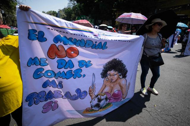 Sex workers hold a banner reading "The World Cup does not feed me, my work does" as they protest for better working conditions amid restrictions linked to the upcoming FIFA 2026 World Cup imposed by the Mexican government, in Mexico City, on International Workers Day, on May 1, 2026. (Photo by CARL DE SOUZA / AFP)