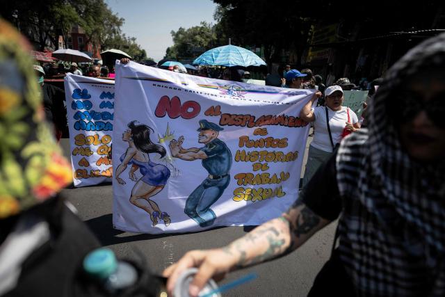 Sex workers hold a banner reading "No to the displacement of historic sex work areas" as they protest for better working conditions amid restrictions linked to the upcoming FIFA 2026 World Cup imposed by the Mexican government, in Mexico City, on International Workers Day, on May 1, 2026. (Photo by CARL DE SOUZA / AFP)
